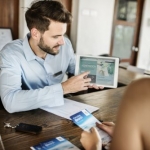 kitchen designer showing woman plans on laptop